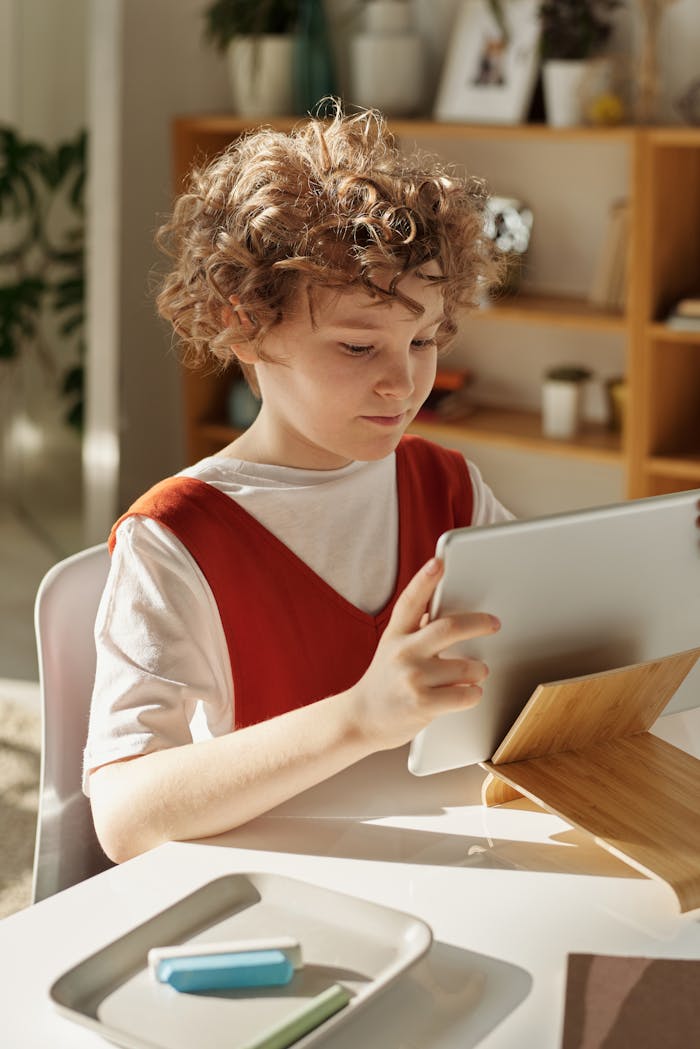 Young girl using a tablet for online learning at home during daytime.